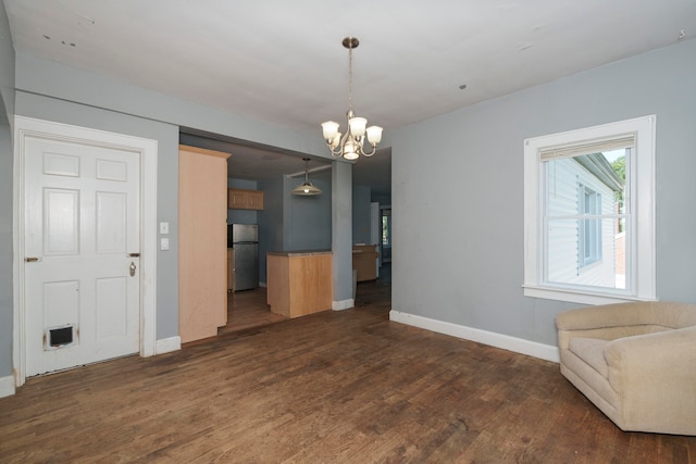 unfurnished dining area with dark hardwood / wood-style flooring and a chandelier