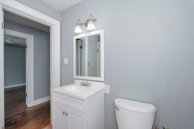 bathroom featuring toilet, vanity, and wood-type flooring