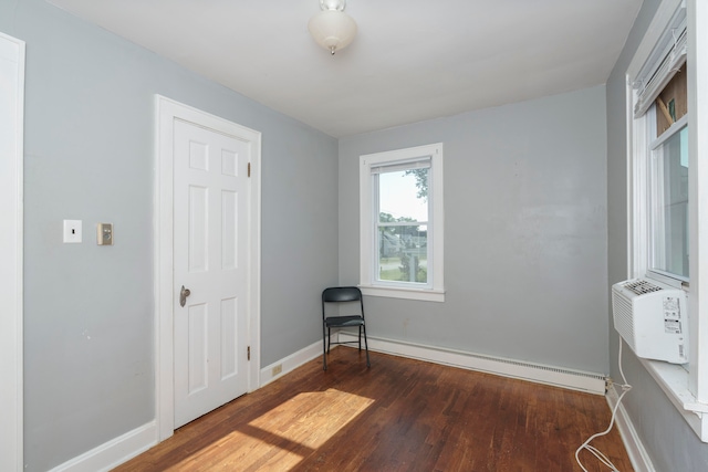 bedroom with hardwood / wood-style floors and a baseboard radiator