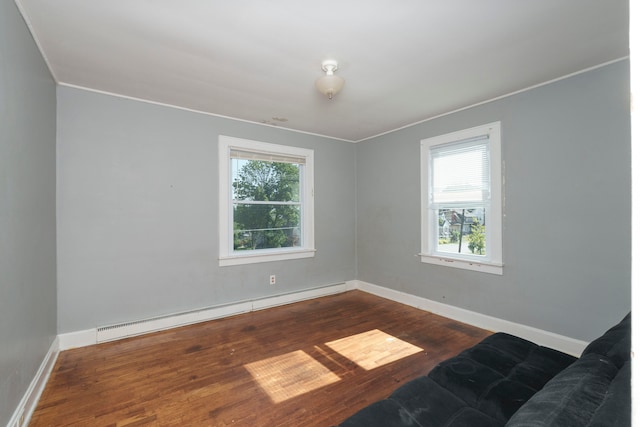 spare room featuring hardwood / wood-style flooring and a baseboard heating unit