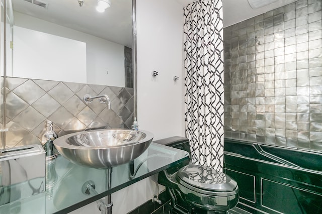 bathroom featuring tile walls and toilet