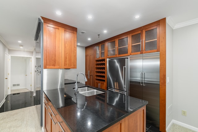 kitchen featuring hardwood / wood-style floors, stainless steel refrigerator, sink, crown molding, and dark stone countertops