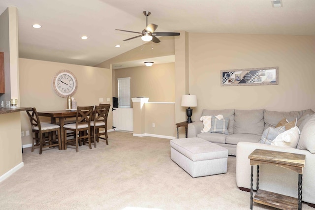 carpeted living room with ceiling fan and vaulted ceiling