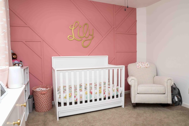 carpeted bedroom featuring a nursery area