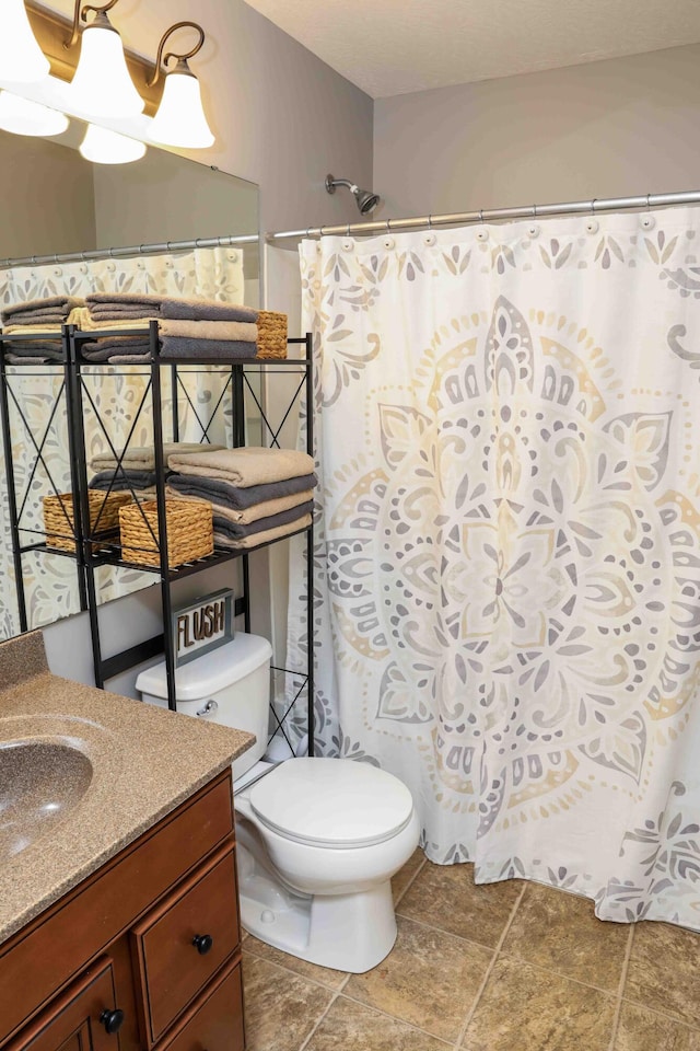 bathroom with tile patterned flooring, an inviting chandelier, toilet, and vanity