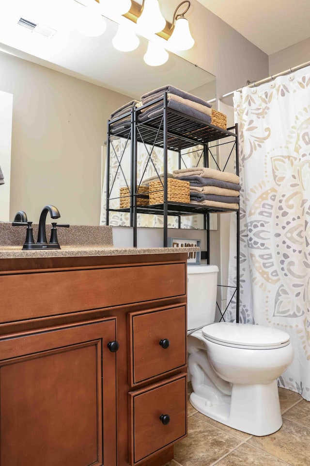 bathroom featuring toilet, tile patterned floors, and vanity