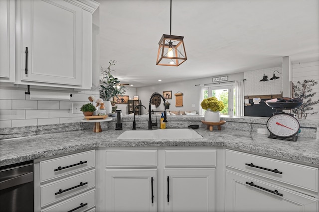 kitchen with open floor plan, backsplash, a sink, and white cabinetry