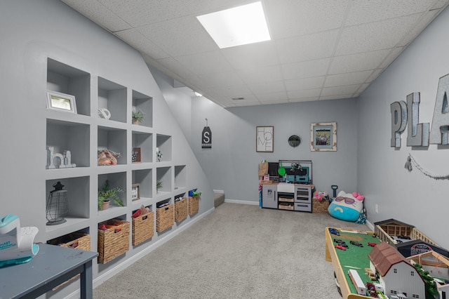 rec room featuring carpet floors, baseboards, built in features, and a drop ceiling