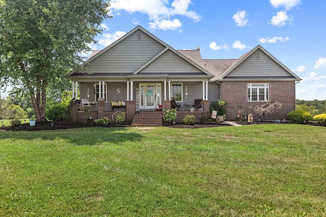 craftsman inspired home with covered porch, brick siding, and a front yard