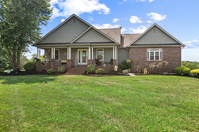 craftsman house with covered porch, brick siding, and a front yard