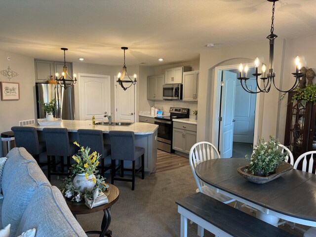 dining room with dark hardwood / wood-style floors, sink, and an inviting chandelier