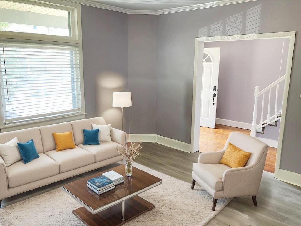 living room featuring crown molding, plenty of natural light, stairway, and wood finished floors