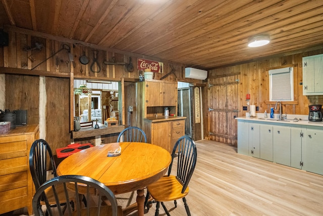 dining area with light hardwood / wood-style flooring, wood walls, sink, and wooden ceiling