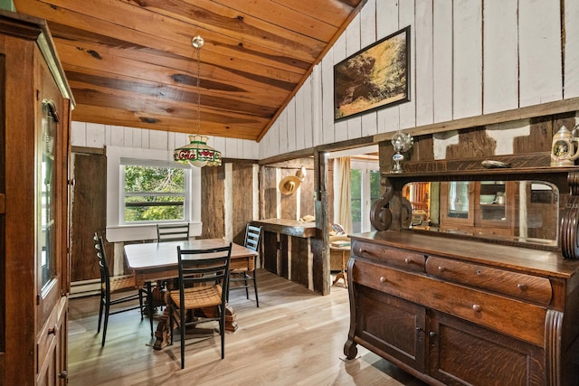 dining space featuring wooden ceiling, vaulted ceiling, light hardwood / wood-style flooring, and wooden walls