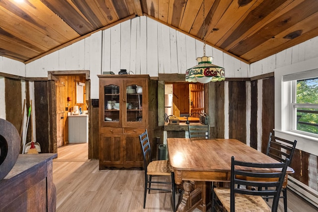 dining space featuring wooden walls, vaulted ceiling, light wood-type flooring, wood ceiling, and baseboard heating