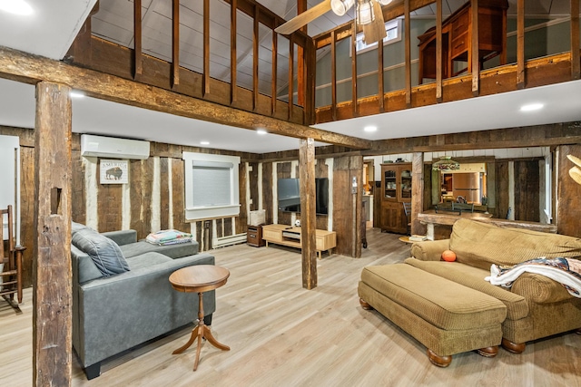 living room featuring a wall mounted AC, a towering ceiling, hardwood / wood-style floors, and decorative columns