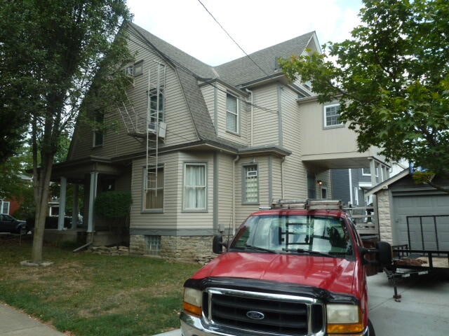 victorian house featuring a garage and a front lawn