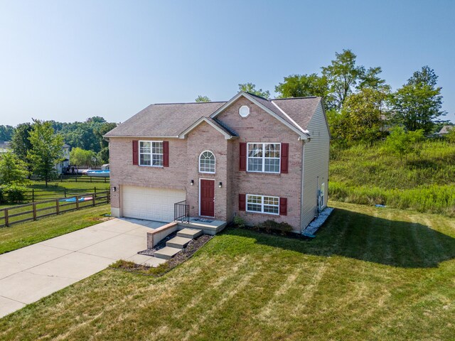 bi-level home featuring a garage and a front yard