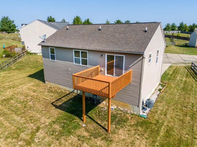 back of property with cooling unit, a deck, and a lawn