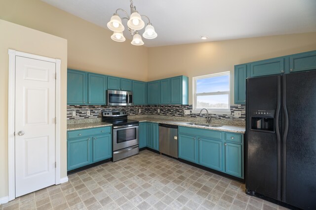 kitchen featuring appliances with stainless steel finishes, vaulted ceiling, pendant lighting, sink, and a notable chandelier