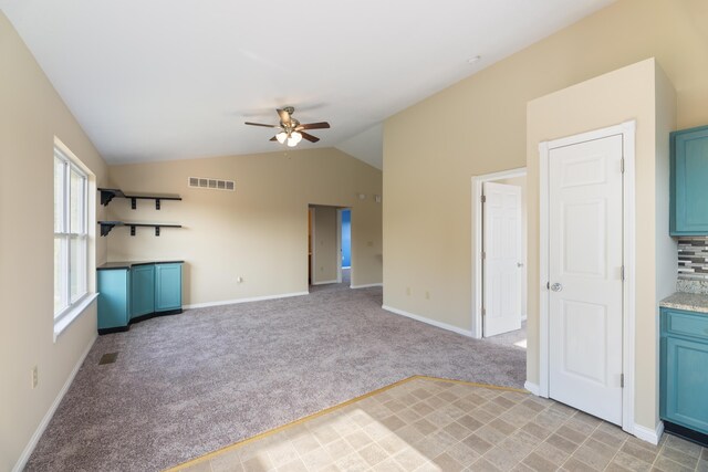 unfurnished living room featuring lofted ceiling, ceiling fan, and light colored carpet