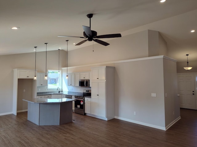 kitchen featuring appliances with stainless steel finishes, white cabinetry, dark wood-type flooring, ceiling fan, and sink