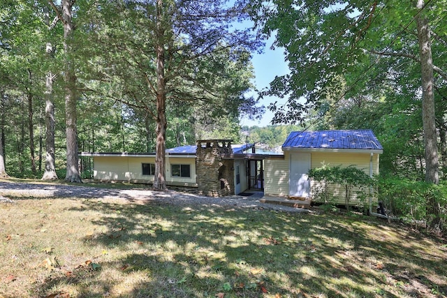 view of front of home with a front yard and metal roof
