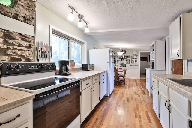 kitchen featuring white cabinets, white appliances, and a textured ceiling