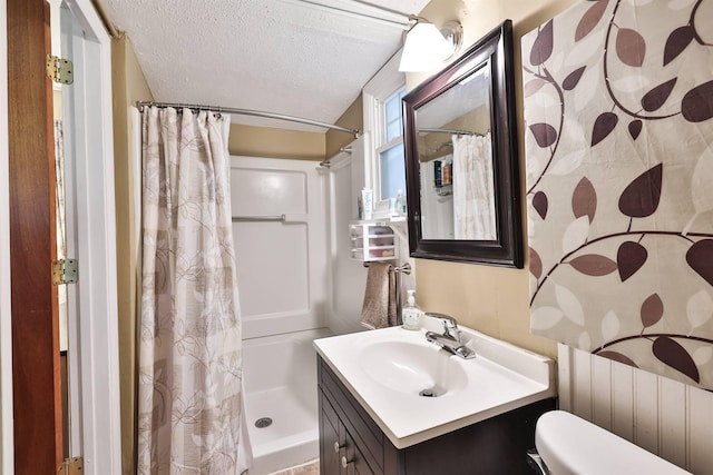 full bathroom with a textured ceiling, toilet, vanity, and a shower with curtain
