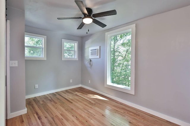 spare room featuring a wealth of natural light, wood-type flooring, and ceiling fan