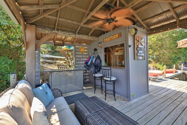 deck with outdoor dry bar, an outdoor living space, and ceiling fan