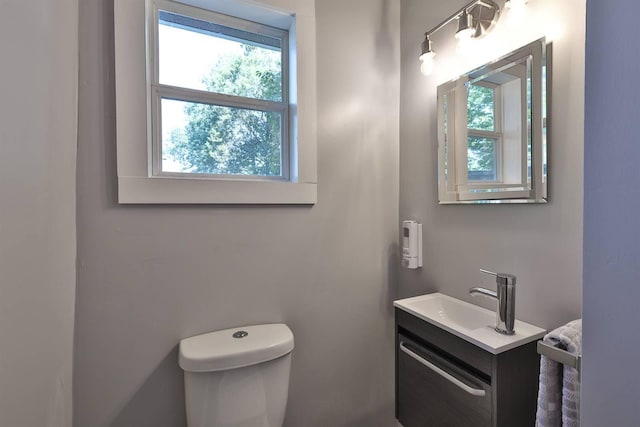 bathroom featuring toilet, a wealth of natural light, and vanity