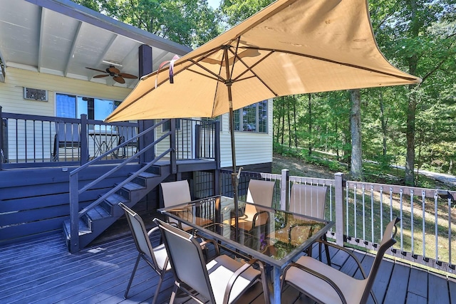 wooden terrace with outdoor dining area, stairway, and a ceiling fan