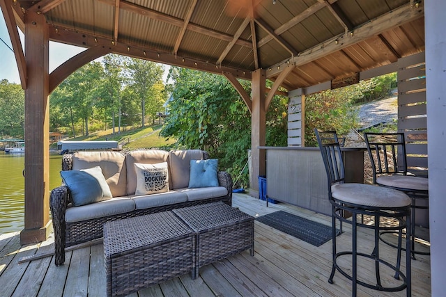 wooden deck featuring a gazebo, an outdoor hangout area, and a water view