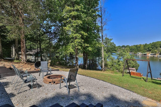 view of patio / terrace with a fire pit and a water view