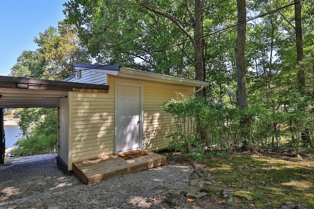 view of property exterior with a carport and an outdoor structure