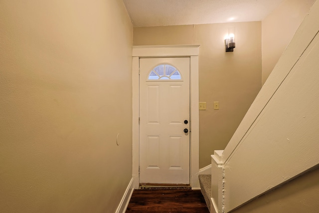 doorway to outside featuring a textured ceiling and dark wood-type flooring