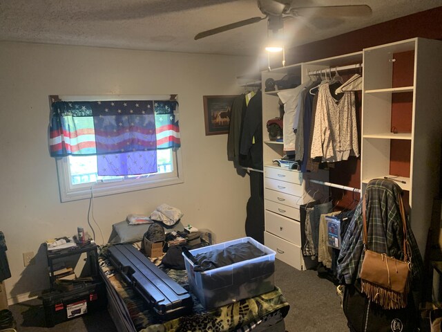 carpeted bedroom with ceiling fan and a textured ceiling