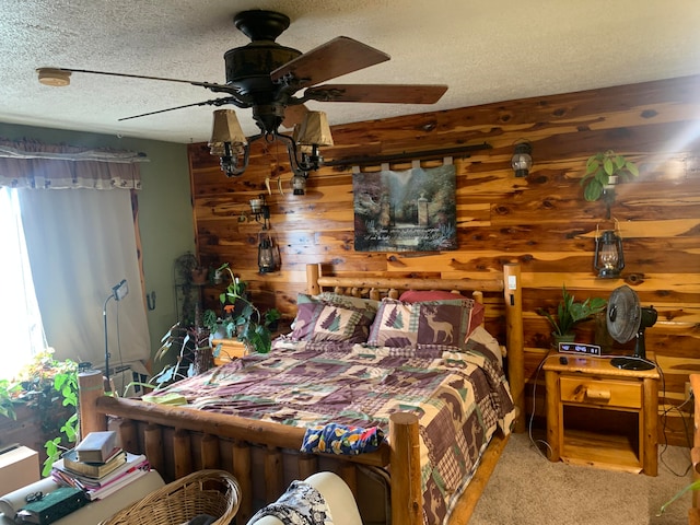 carpeted bedroom featuring ceiling fan, wooden walls, and a textured ceiling