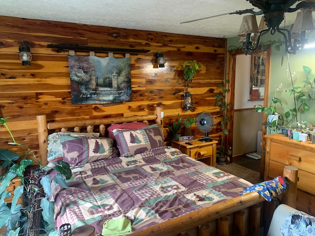 bedroom with a textured ceiling and wood walls