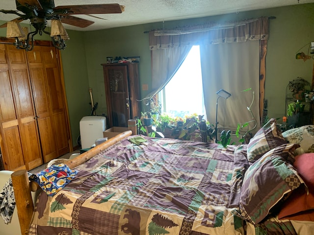 bedroom with ceiling fan and a textured ceiling