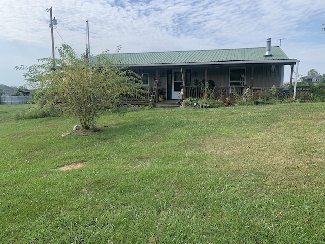 view of front of property featuring metal roof, a porch, board and batten siding, and a front yard