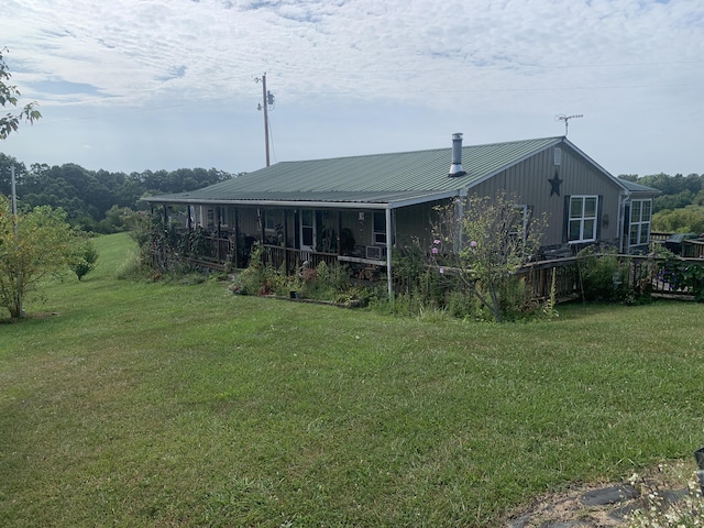 exterior space with metal roof and a yard