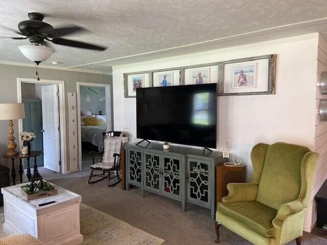 living room featuring crown molding, ceiling fan, carpet floors, and a textured ceiling