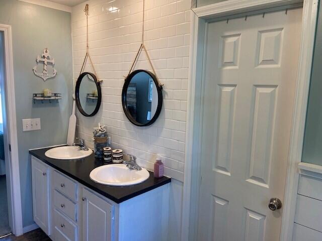 bathroom featuring vanity and backsplash