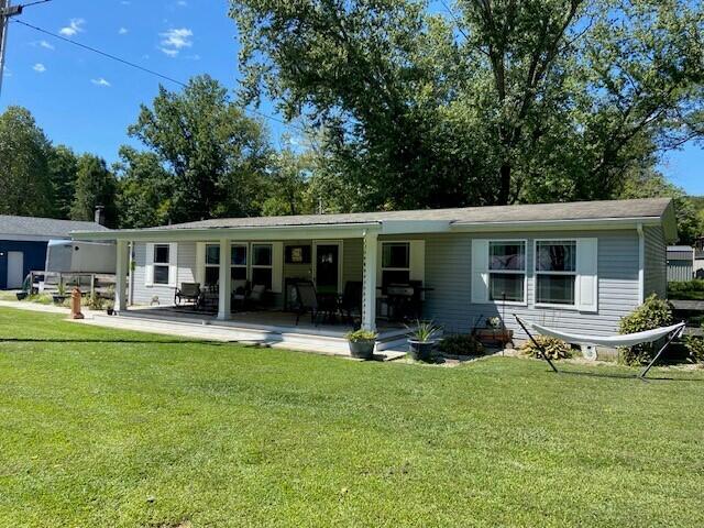 back of house with a lawn and a patio area