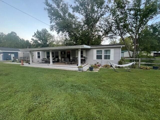 rear view of house with a patio area and a lawn