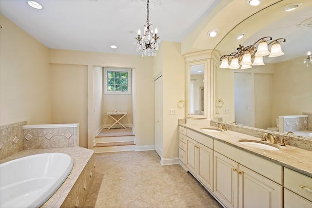 bathroom featuring vanity, a chandelier, and a relaxing tiled tub