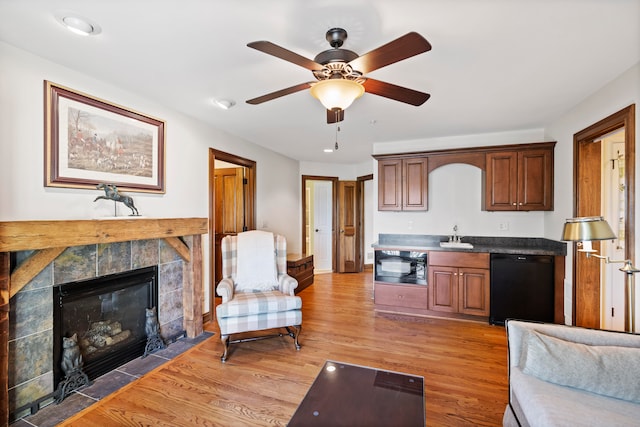 living room featuring a fireplace, hardwood / wood-style floors, and ceiling fan