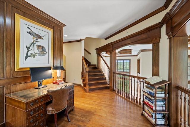 office with light wood-type flooring, wooden walls, decorative columns, and ornamental molding